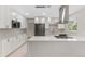 Stylish kitchen featuring white cabinets, stainless steel appliances, and a contemporary backsplash at 12992 W Jewell Cir, Lakewood, CO 80228