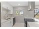 Updated kitchen features stainless steel appliances, white cabinets, and a modern backsplash at 12992 W Jewell Cir, Lakewood, CO 80228
