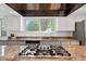 Close up of granite countertops, stainless steel gas cooktop, and bright window views at 4850 S Kittredge St, Aurora, CO 80015