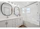 Bright bathroom featuring double sink vanity, framed mirrors, tub, and shower at 748 Poppywood Pl, Highlands Ranch, CO 80126