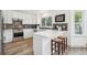 Bright kitchen features white cabinetry, stainless steel appliances, and a breakfast bar with seating for casual dining at 748 Poppywood Pl, Highlands Ranch, CO 80126