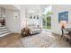 Bright living room with large windows, sliding door to the backyard, couch, rug, and wood grain flooring at 748 Poppywood Pl, Highlands Ranch, CO 80126