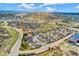 Houses in community, aerial view; features mountain views, green hills, neighborhood streets, and nice landscaping at 627 Millbrook Cir, Castle Rock, CO 80109