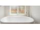 Modern white bathtub with chrome faucet and window at 627 Millbrook Cir, Castle Rock, CO 80109