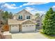 Charming two-story home with stone accents, a three-car garage, and a well-manicured front lawn at 627 Millbrook Cir, Castle Rock, CO 80109