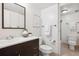 Well-lit bathroom with a dark vanity and mirror, toilet, and walk-in shower at 4801 E 9Th Ave # 402S, Denver, CO 80220
