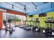 Bright gym with state-of-the-art treadmills and elliptical machines overlooking green outdoor space at 4801 E 9Th Ave # 402S, Denver, CO 80220
