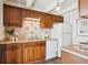 Well-lit kitchen featuring tile backsplash, countertops, wooden cabinets, and modern appliances at 4801 E 9Th Ave # 402S, Denver, CO 80220
