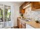 Open concept kitchen with tile backsplash, countertops, wooden cabinets, and balcony access at 4801 E 9Th Ave # 402S, Denver, CO 80220