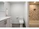 Bathroom view showcasing a luxurious tub with elegant marble tiling and a modern toilet at 14150 E Temple Dr # V06, Aurora, CO 80015