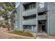 Condominium exterior shows three stories with a stairway and balconies, all surrounded by mature trees at 14150 E Temple Dr # V06, Aurora, CO 80015