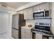 Modern kitchen with stainless steel appliances and gray cabinets offers a contemporary culinary space at 14150 E Temple Dr # V06, Aurora, CO 80015