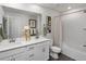 Bright bathroom with double sink vanity, framed mirror, tiled shower, and neutral color palette creates a clean, modern space at 14492 Pansy Loop, Morrison, CO 80465
