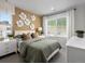 Inviting bedroom with a neutral color scheme, soft green bedding, decorative wall flowers, and large window with natural light at 14492 Pansy Loop, Morrison, CO 80465
