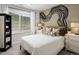 Stylish bedroom with a unique painted accent wall, comfortable bed, and a bright window provides natural light and views at 14492 Pansy Loop, Morrison, CO 80465