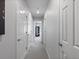 Bright hallway featuring multiple doors, neutral walls, and carpet leading to various rooms in the home at 14492 Pansy Loop, Morrison, CO 80465