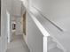 Well-lit stairway featuring modern railings, neutral walls, and carpeted steps leading to the upper level of the home at 14492 Pansy Loop, Morrison, CO 80465