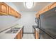 Functional kitchen with oak cabinetry, black appliances, and tile flooring at 707 W 96Th Ave # 5, Thornton, CO 80260