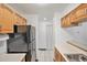 Functional kitchen with oak cabinetry, black appliances, and tile flooring at 707 W 96Th Ave # 5, Thornton, CO 80260