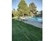 Community pool with lounge chairs surrounded by green grass and mature trees at 707 W 96Th Ave # 5, Thornton, CO 80260