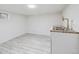A finished basement area showcasing a utility sink and modern vinyl flooring at 3110 W 66Th Ave, Denver, CO 80221