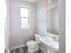 A cozy powder room featuring a modern toilet, pedestal sink, and a wall-mounted mirror at 8722 E 47Th Ave, Denver, CO 80238