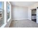 Bedroom with large window features plush carpet, neutral walls and access to a bathroom through barn doors at 8722 E 47Th Ave, Denver, CO 80238