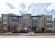 A modern townhouse exterior with brick and siding details, set against a cloudy sky at 8722 E 47Th Ave, Denver, CO 80238