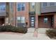 A close-up of a modern townhome exterior showing brick accents and a stylish front door with sidelights at 8722 E 47Th Ave, Denver, CO 80238