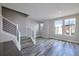 A bright living room featuring hard surface floors, staircase, and large windows at 8722 E 47Th Ave, Denver, CO 80238