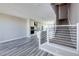 Bright, open-concept living space showcases modern staircase, gray flooring, and a sleek, white kitchen at 8722 E 47Th Ave, Denver, CO 80238