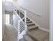 Carpeted staircase featuring contemporary white railings and metal balusters leading to the upper level at 8722 E 47Th Ave, Denver, CO 80238