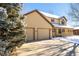 Two-story house with beige siding, attached two-car garage, and a covered porch at 1506 Maple Dr, Berthoud, CO 80513