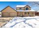 Tan two-story house with a double garage and snowy front yard at 1506 Maple Dr, Berthoud, CO 80513