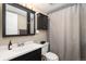Updated bathroom with sleek vanity, medicine cabinet, and shower with curtain at 13744 E Lehigh Ave # B, Aurora, CO 80014