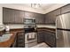 Modern kitchen featuring stainless steel appliances and wooden cabinets at 13744 E Lehigh Ave # B, Aurora, CO 80014