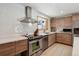 Modern kitchen featuring stainless appliances, white countertops and wooden cabinetry with hood and backsplash tiles at 8540 W 59Th Ave, Arvada, CO 80004
