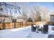 Backyard with snow, wooden fence, and patio furniture at 10283 Spotted Owl Ave, Highlands Ranch, CO 80129