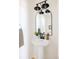 Small bathroom with pedestal sink, arched mirror, and modern lighting at 10283 Spotted Owl Ave, Highlands Ranch, CO 80129