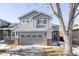 Gray two-story house with a three-car garage and mature tree in front at 10283 Spotted Owl Ave, Highlands Ranch, CO 80129