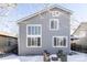 Gray house exterior with patio furniture, large windows, and snowy yard at 10283 Spotted Owl Ave, Highlands Ranch, CO 80129