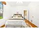Bright bedroom features a plush bed, hardwood floors, ensuite bathroom, and a ceiling fan at 3147 W 39Th Ave, Denver, CO 80211
