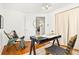 Home office features hardwood floors, a modern black desk, and a comfortable accent chair at 3147 W 39Th Ave, Denver, CO 80211