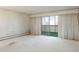 Bright living room with balcony access and white carpet at 3470 S Poplar St # 401, Denver, CO 80224