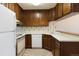 Kitchen with white appliances, wood cabinets, and white countertops at 3470 S Poplar St # 401, Denver, CO 80224