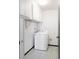 Bright laundry room with a full-size white washing machine, overhead cabinets, and tile floor at 3470 S Poplar St # 401, Denver, CO 80224