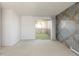 A bright, carpeted living room with geometric wallpaper and sliding glass doors to a balcony at 3470 S Poplar St # 401, Denver, CO 80224