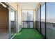 Enclosed patio featuring sliding glass doors, a faux-grass floor, and windows offering outdoor views at 3470 S Poplar St # 401, Denver, CO 80224