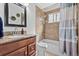 Bathroom with a wood vanity, granite countertop, tiled walls, and a shower/tub combo at 11320 Irma Dr, Northglenn, CO 80233