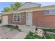 Close up of the front entrance of a charming brick house with a gray door and a small porch at 11320 Irma Dr, Northglenn, CO 80233